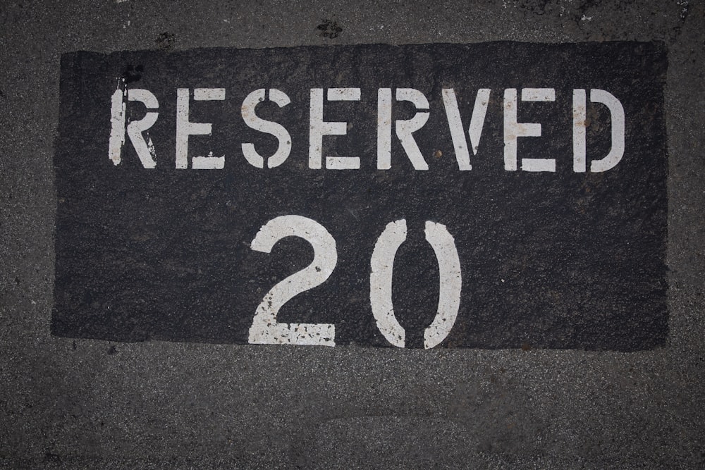 a sign that reads reserved on a sidewalk