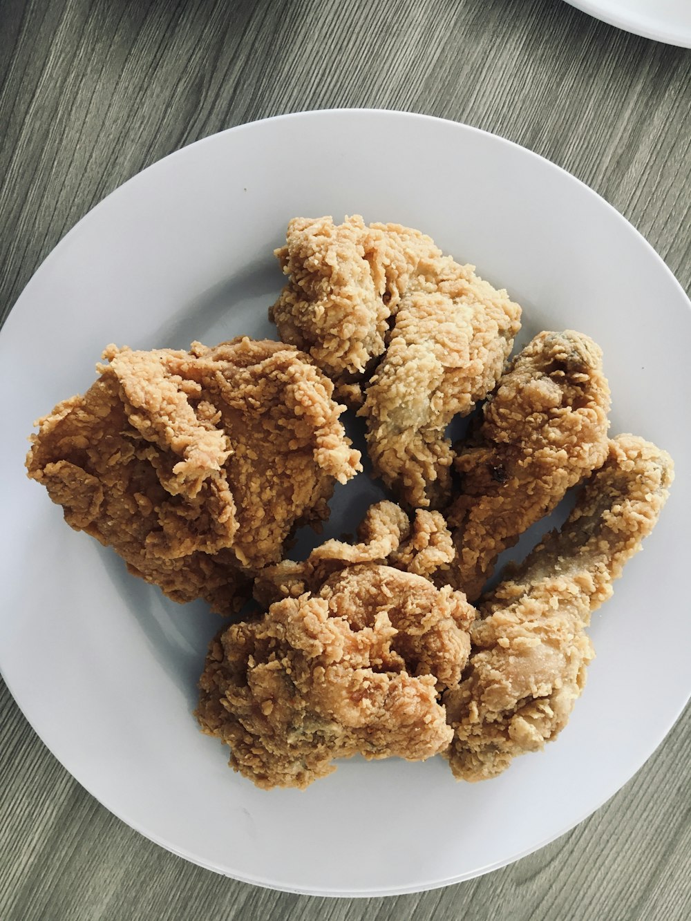 a white plate topped with fried food on top of a wooden table