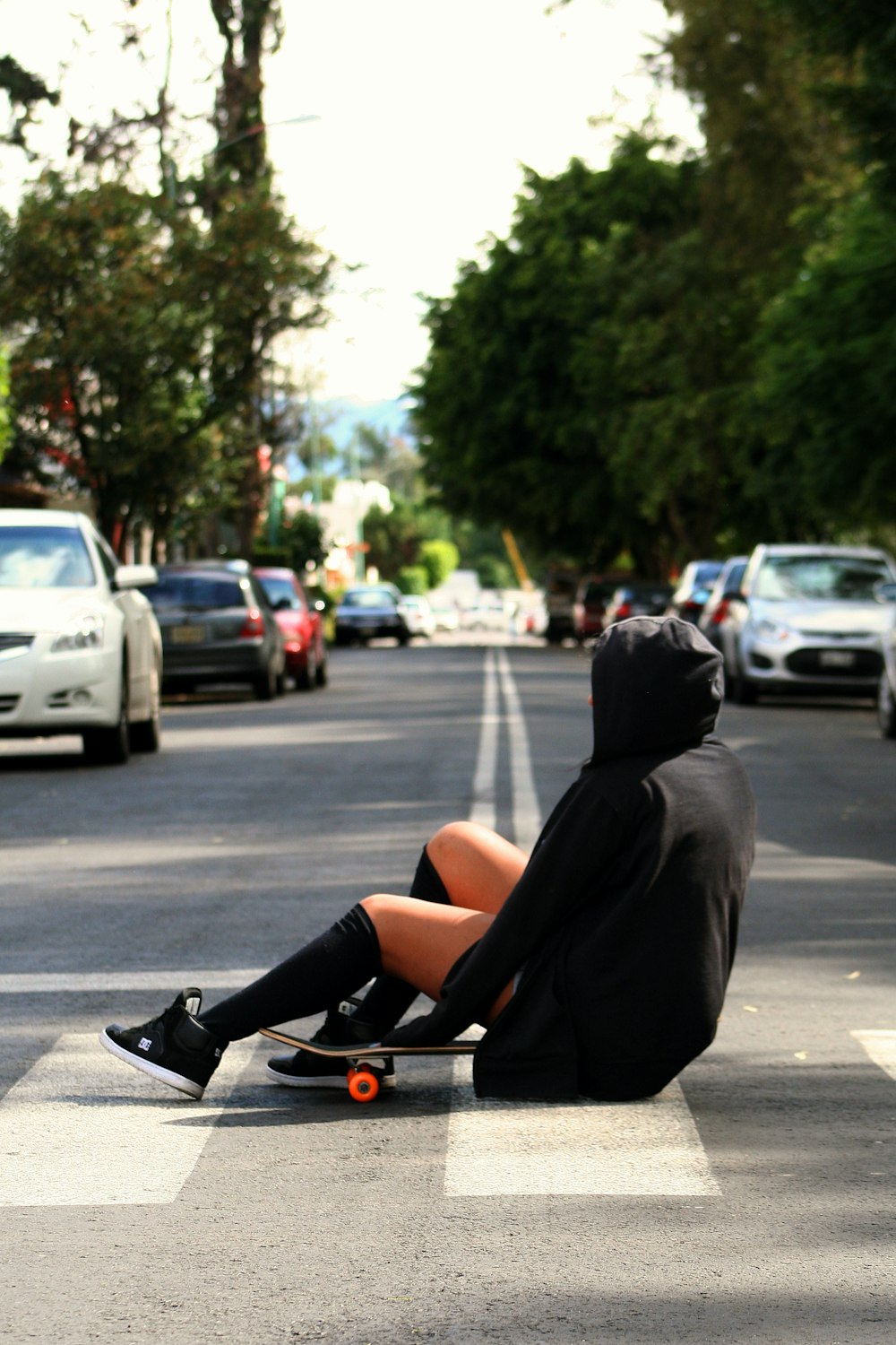 woman in black hoodie sitting on black steel bench during daytime