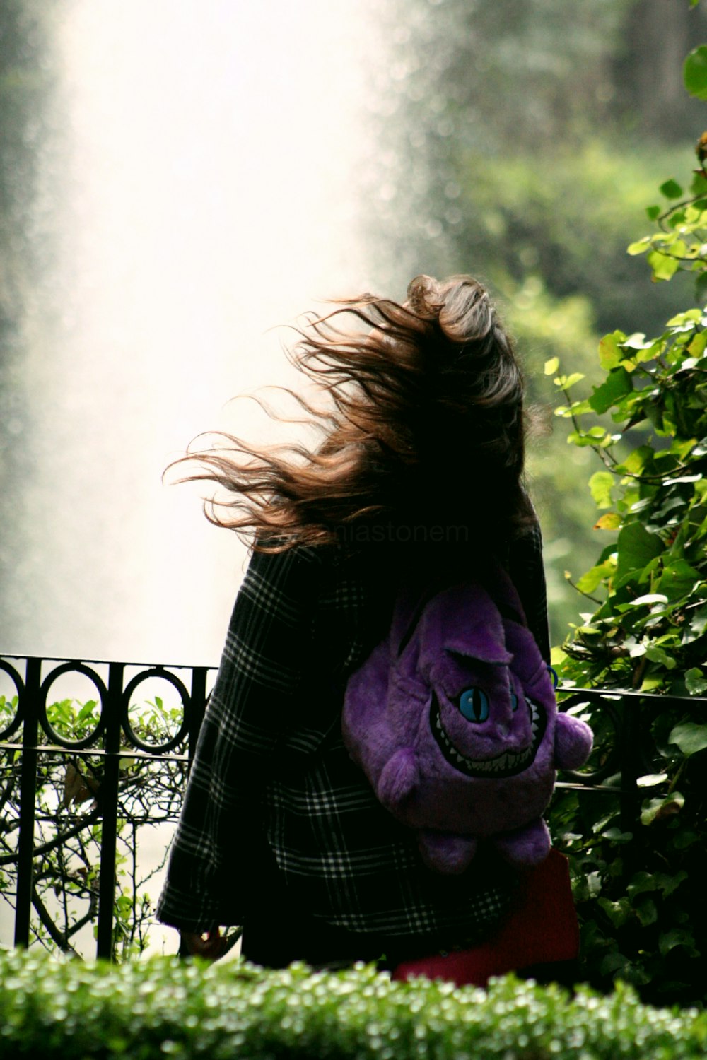 woman in black and white striped long sleeve shirt covering her face with purple scarf