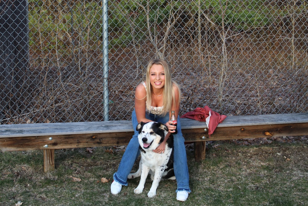 girl in gray t-shirt sitting on brown wooden bench beside white and black short coat