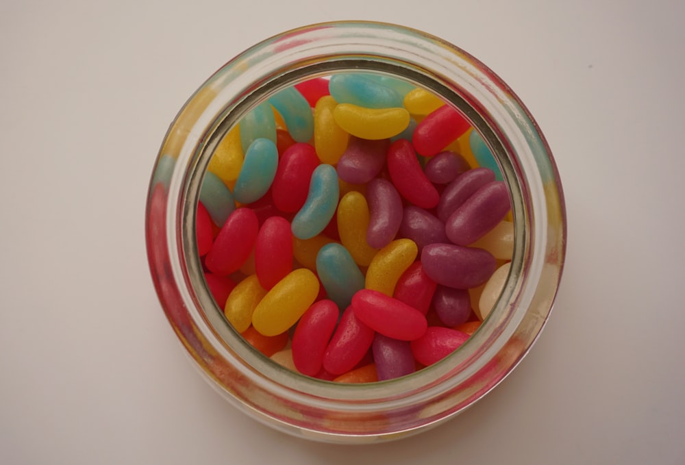 orange and red candies in clear glass jar