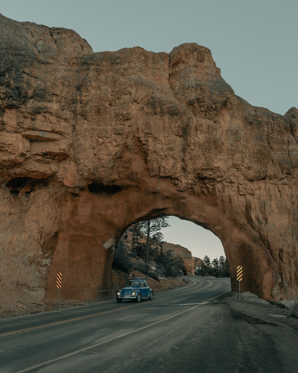 cars on road near brown rock formation during daytime