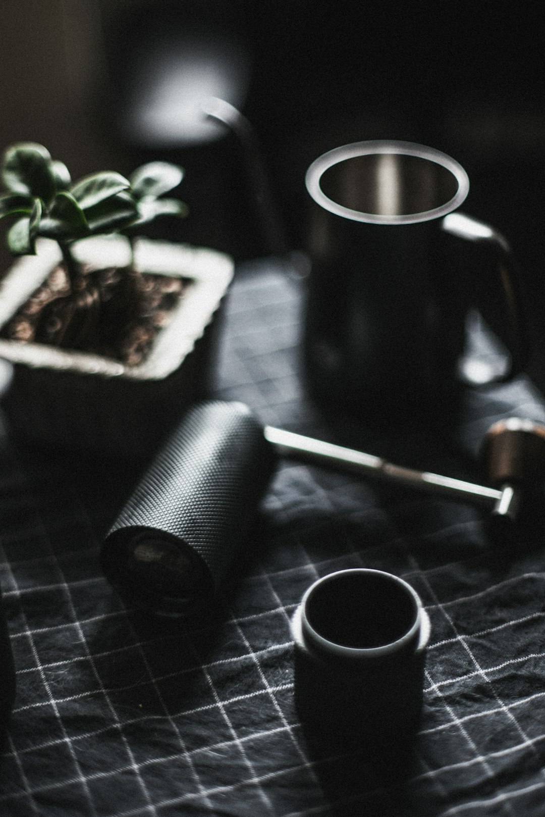 black ceramic mug beside green plant on black wooden table