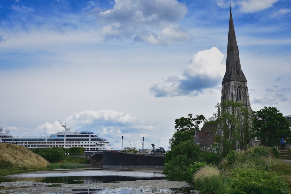 white and gray concrete building near body of water under white clouds during daytime