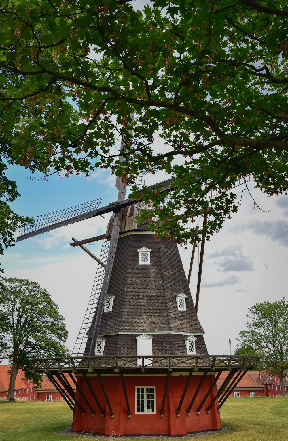 brown brick tower near green trees during daytime