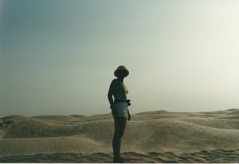 man in black t-shirt and black pants standing on brown sand during daytime