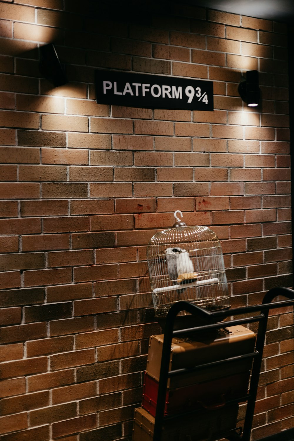 black metal armchair beside brown brick wall