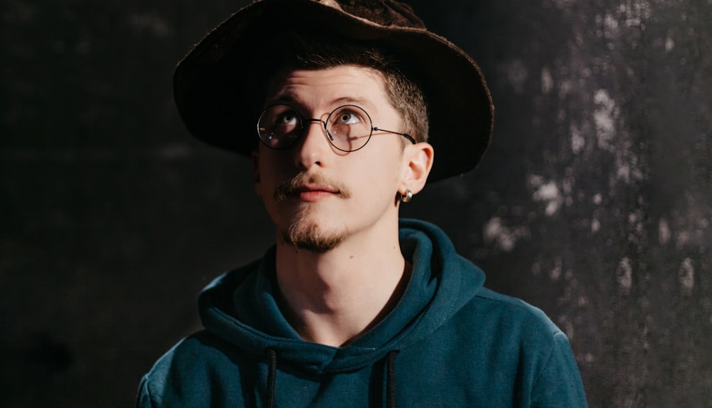 man in blue hoodie wearing black hat