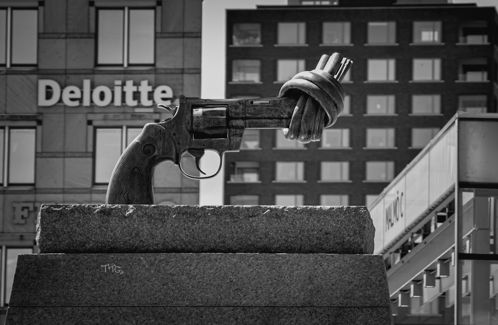 Foto in scala di grigi di una foto in bianco e nero di una persona che tiene in mano una pistola softair