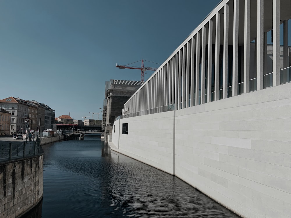 white and black concrete building near body of water during daytime