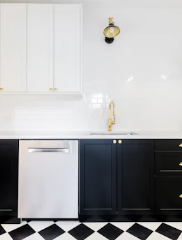 Before and after image of a modern kitchen renovation with sleek black and gold accents.