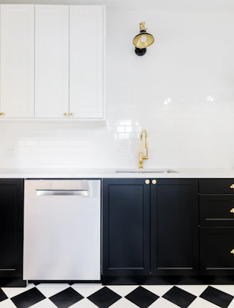 A luxurious black and gold kitchen setup featuring sleek appliances and elegant lighting.