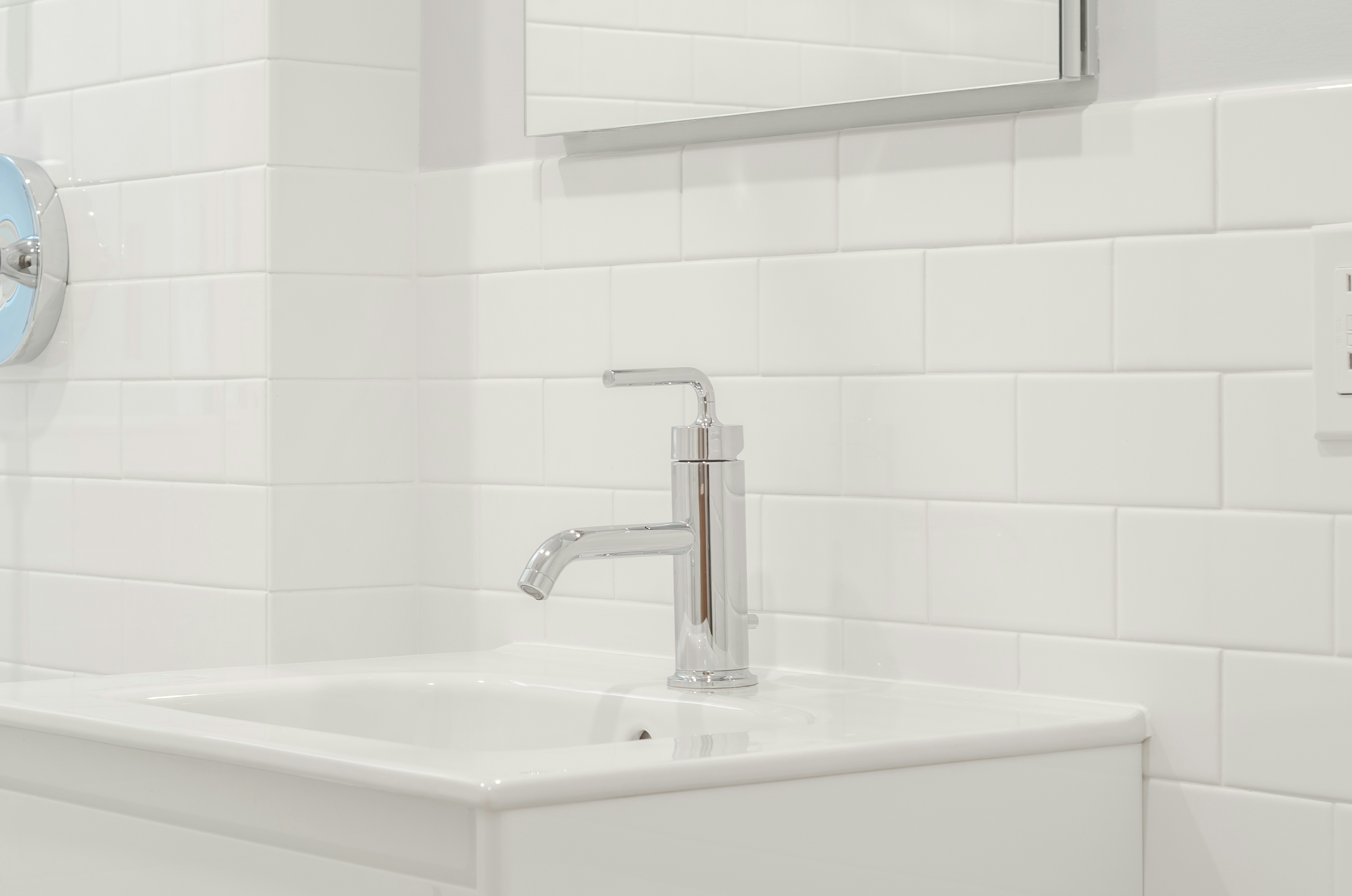 All white bathroom, white bathroom tiles, white subway tiles, chrome faucets, chrome shower head, chrome finishings, bathroom mirror, crystal door knob