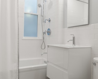 white ceramic bathtub near white bathtub