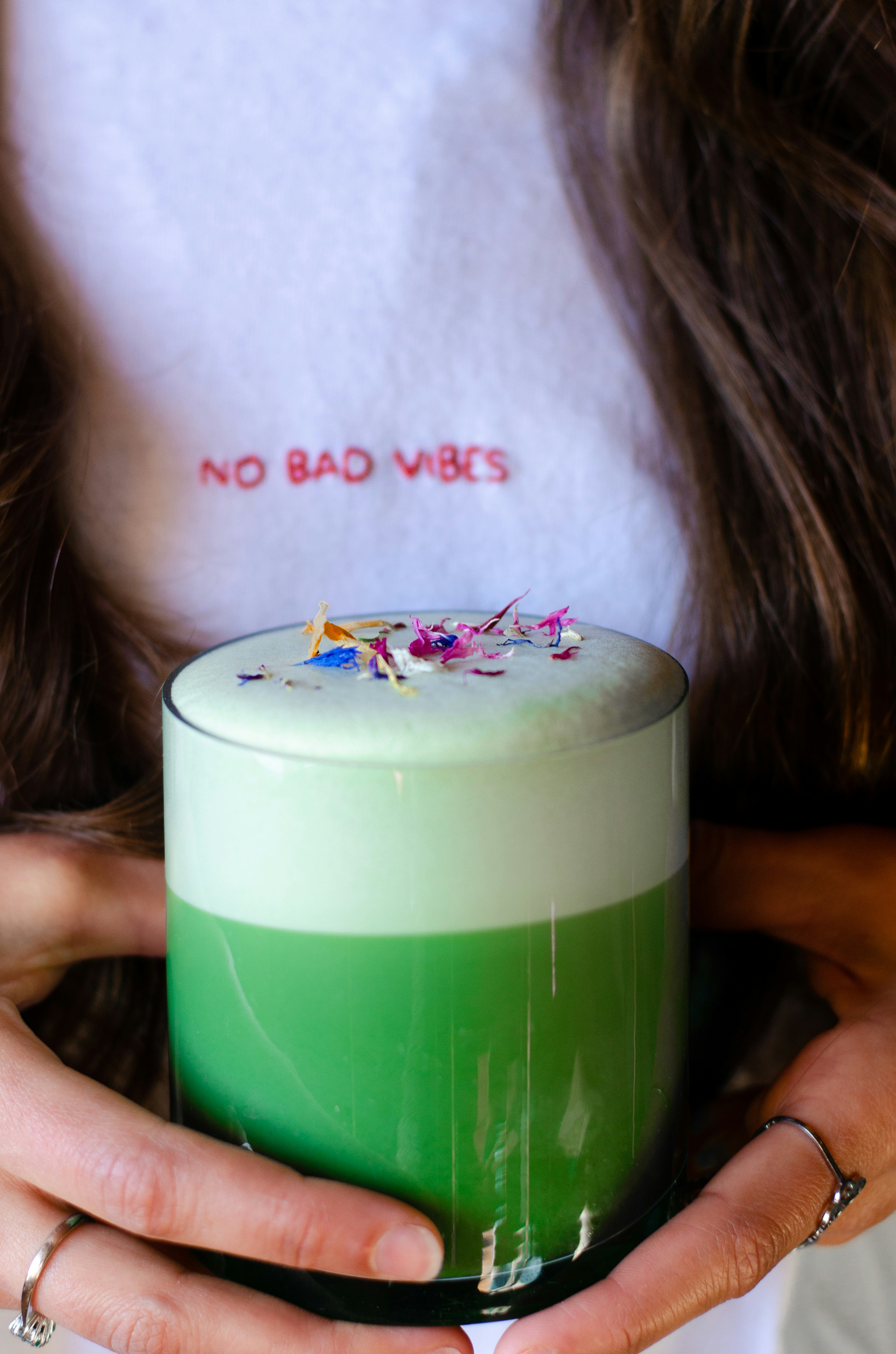 a woman holding a green and white cake in her hands