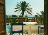 Balcony room with outdoor seating and ocean horizon view.