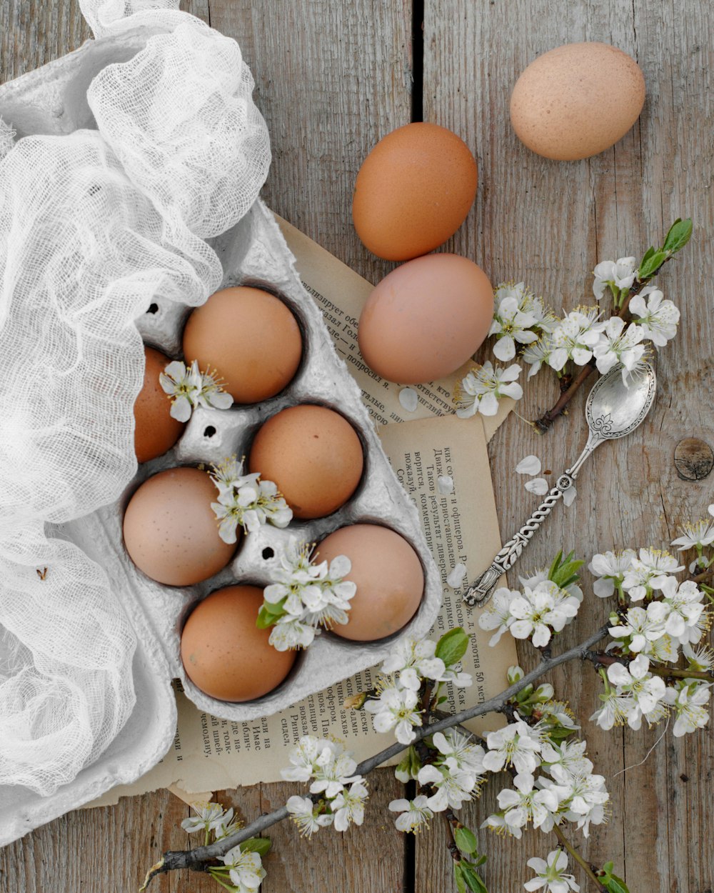 Huevos marrones sobre textil floral blanco