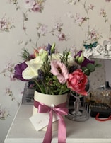 A friendly concierge delivering a small bouquet of flowers during a weekly visit, with warm teal and coral tones in the background.