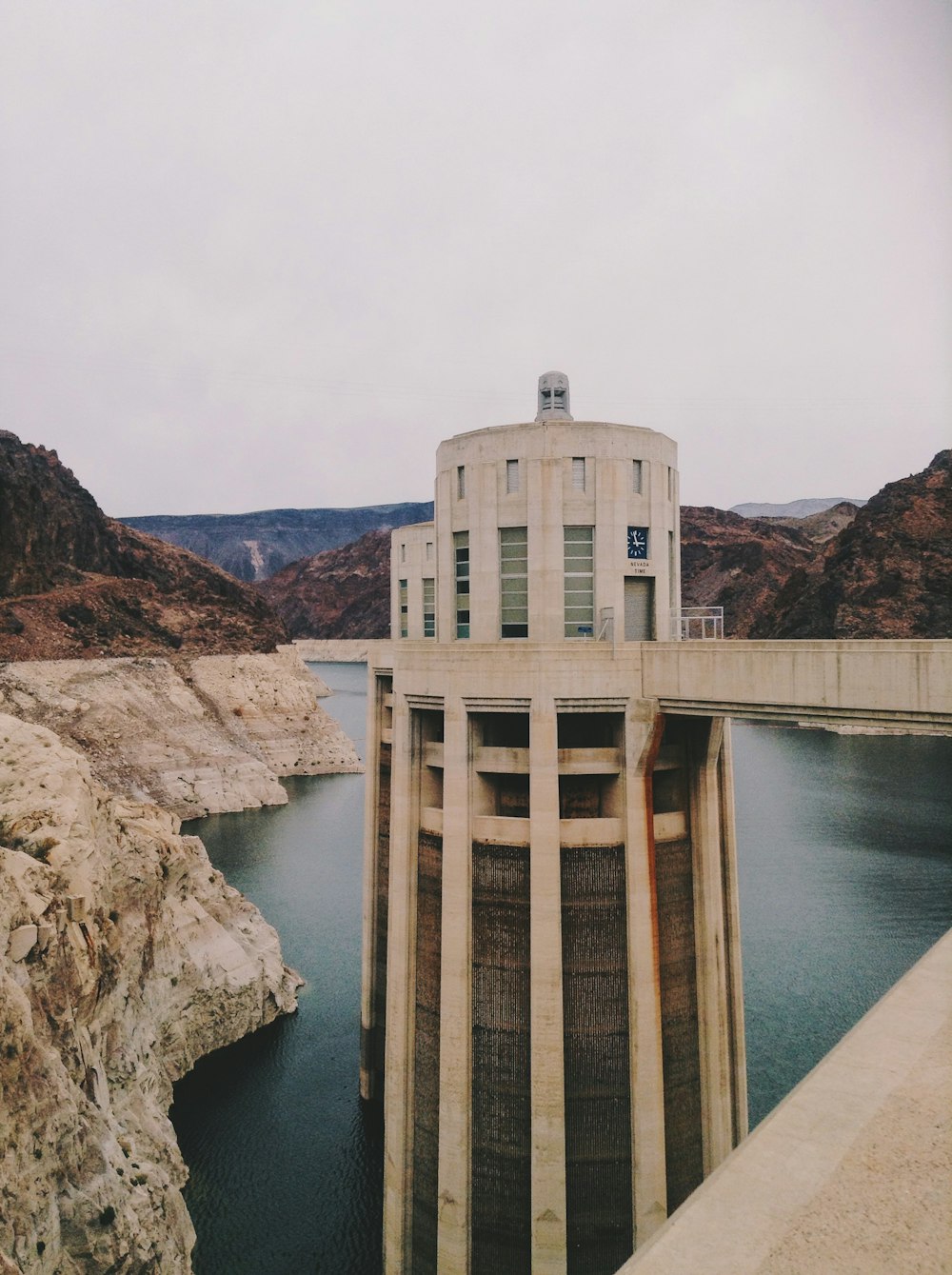 white concrete building on brown rock formation near body of water during daytime