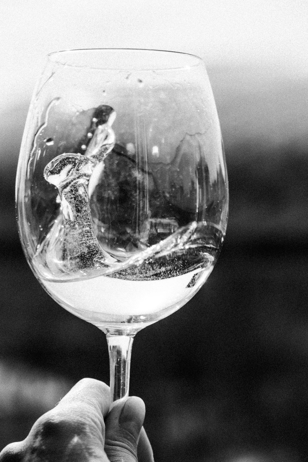 Foto in scala di grigi di un bicchiere di vino trasparente