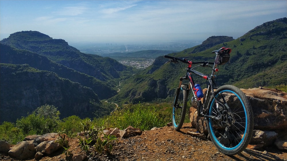 mountain bike blu e nera su strada sterrata marrone durante il giorno