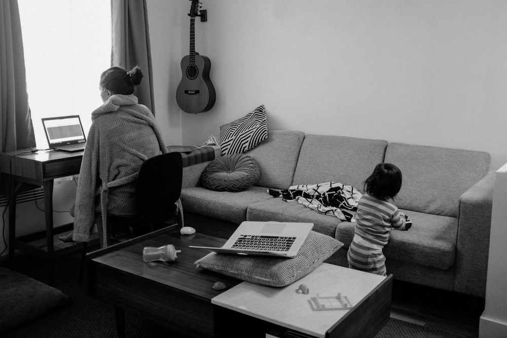 man playing acoustic guitar in grayscale photography