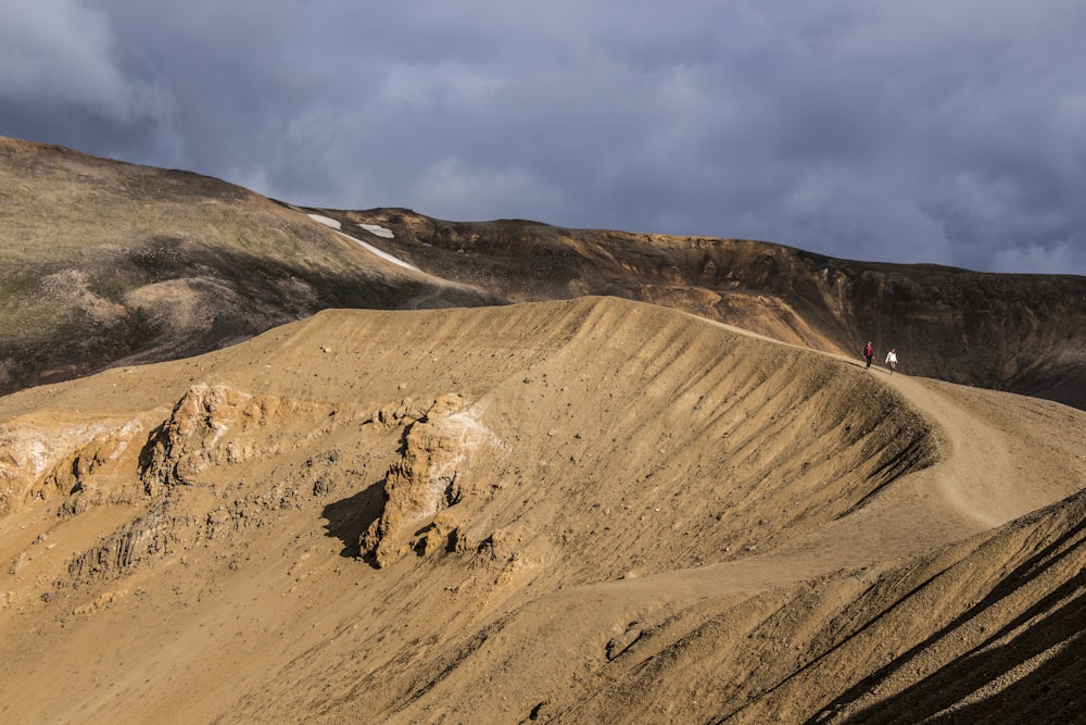 Braune Felsformation unter weißen Wolken tagsüber