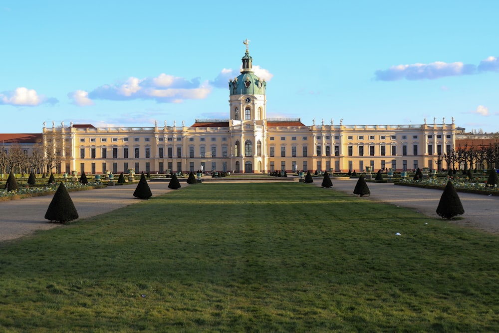 people walking on green grass field near white concrete building during daytime