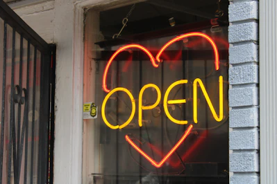 a neon sign that says open in a window