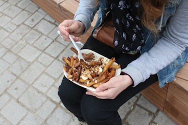 person holding burger with fries