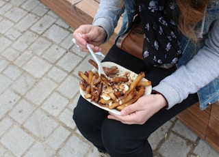 person holding burger with fries