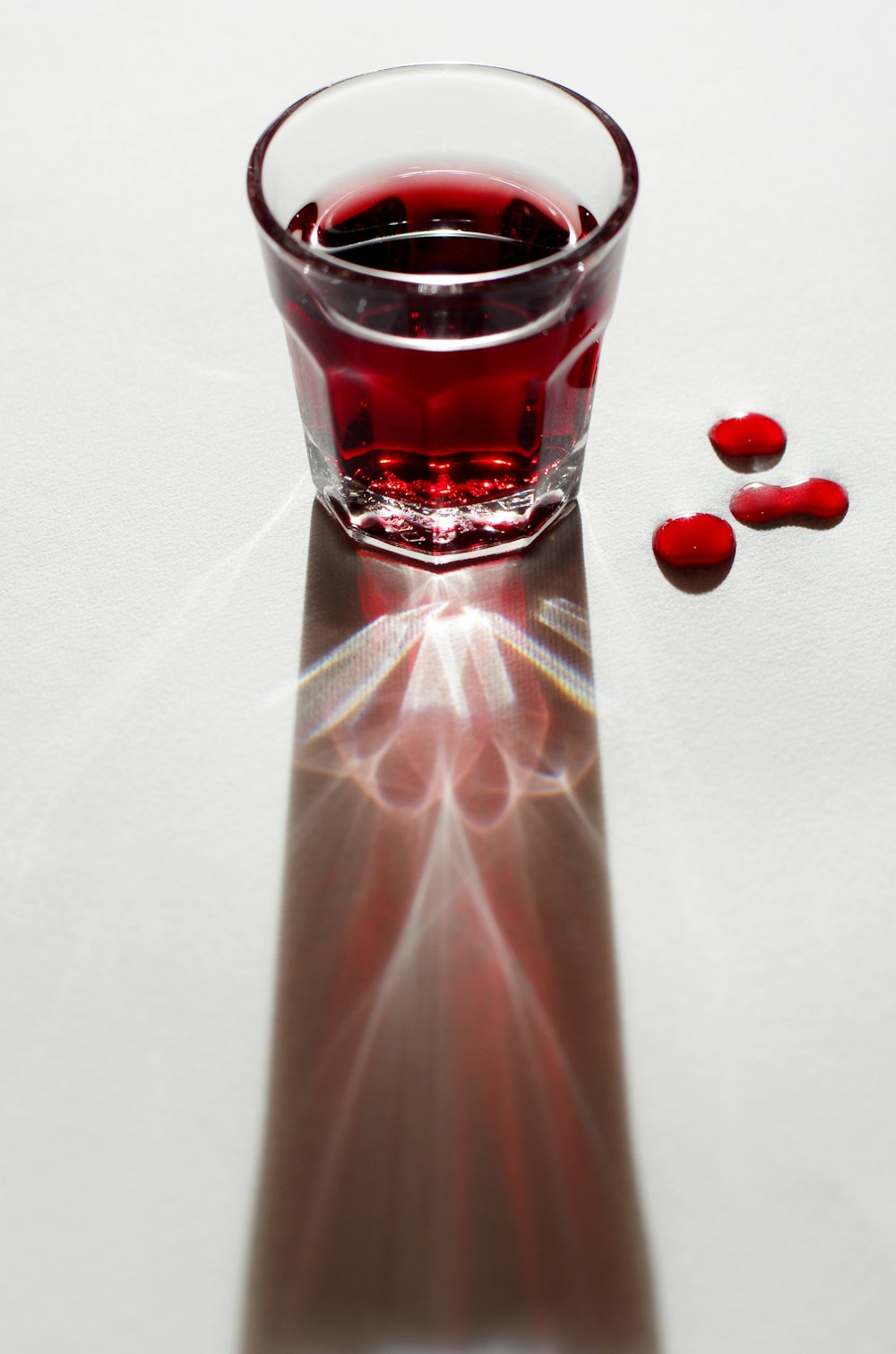 bicchiere trasparente con liquido rosso