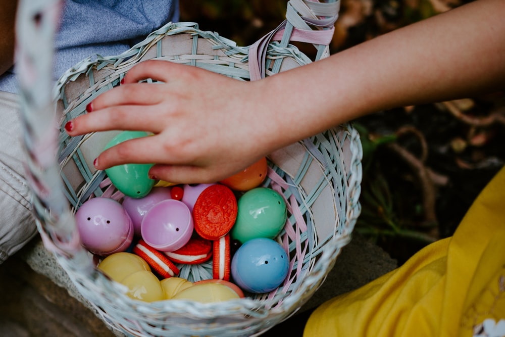 person holding a basket of easter eggs