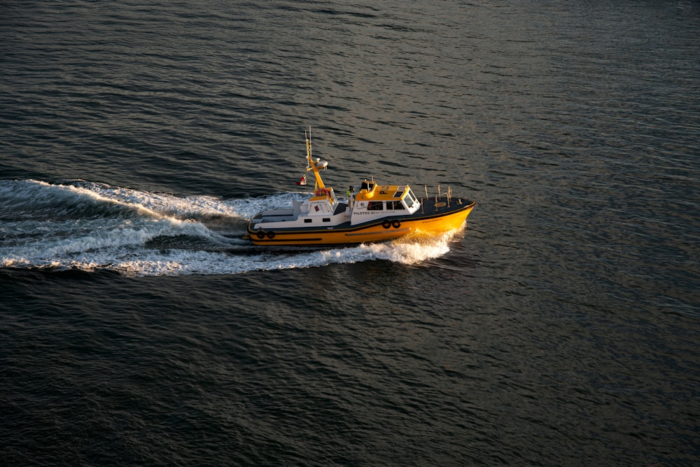 gelb-weißes Boot auf See tagsüber