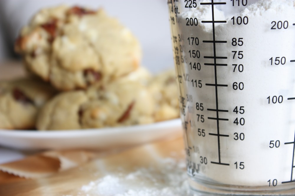 clear glass measuring cup on white ceramic plate