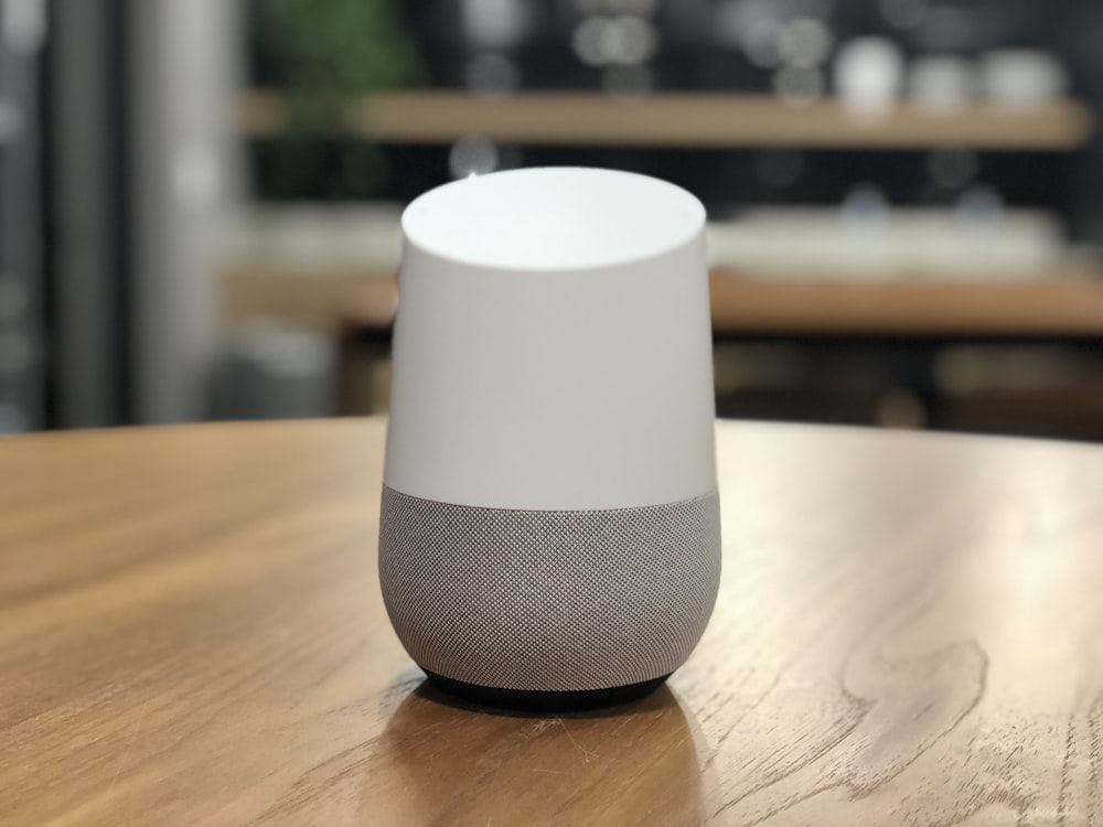 white and black round speaker on brown wooden table