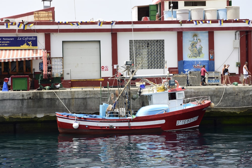 barco vermelho e branco na doca durante o dia