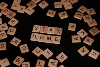 Scrabble tiles spelling 'STAY HOME,' illustrating social isolation and its impact.