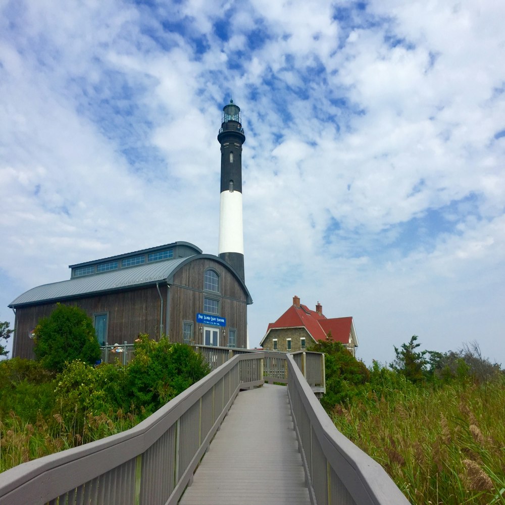 white and black lighthouse under cloudy sky during daytime