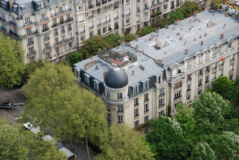 edificio in cemento bianco vicino agli alberi verdi durante il giorno