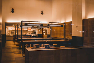 Cozy restaurant interior with minimalist decor and warm lighting highlighting fresh dishes on wooden tables.
