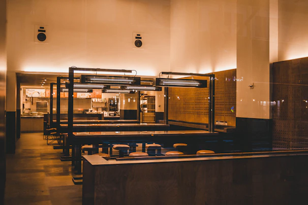 Cozy restaurant interior with minimalist decor and warm lighting highlighting fresh dishes on wooden tables.