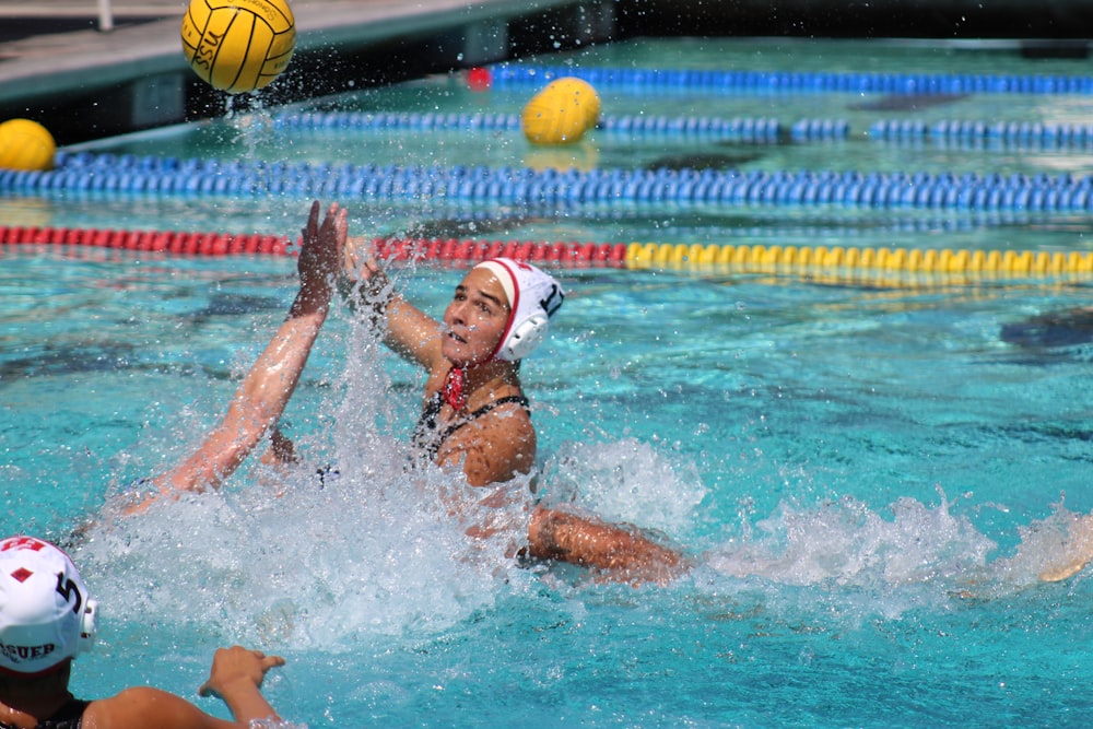 woman in swimming pool with yellow and black volleyball