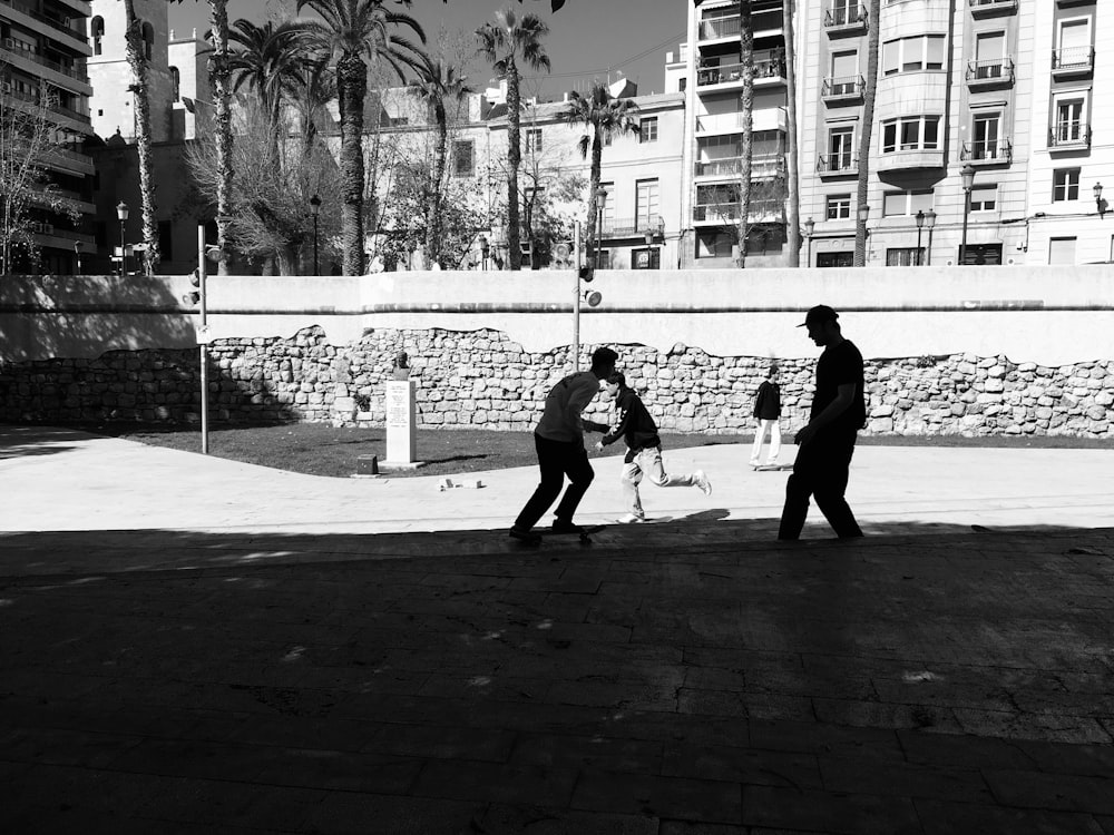 grayscale photo of man and woman walking on sidewalk