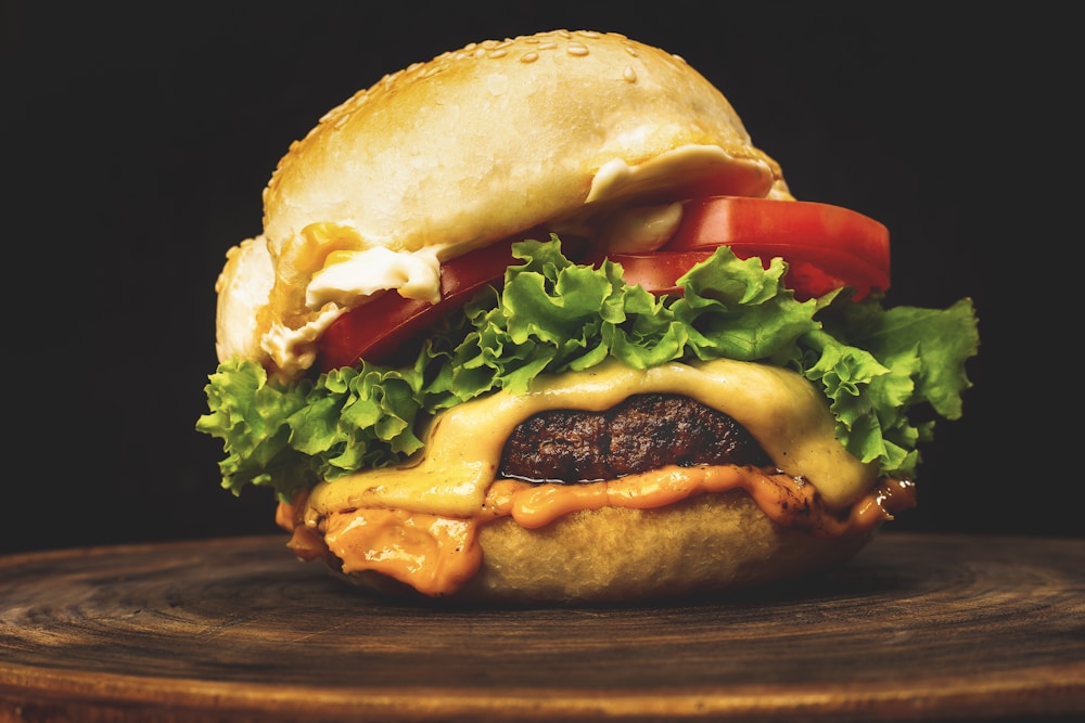 Step-by-step burger recipe assembly with melted cheese and fresh vegetables