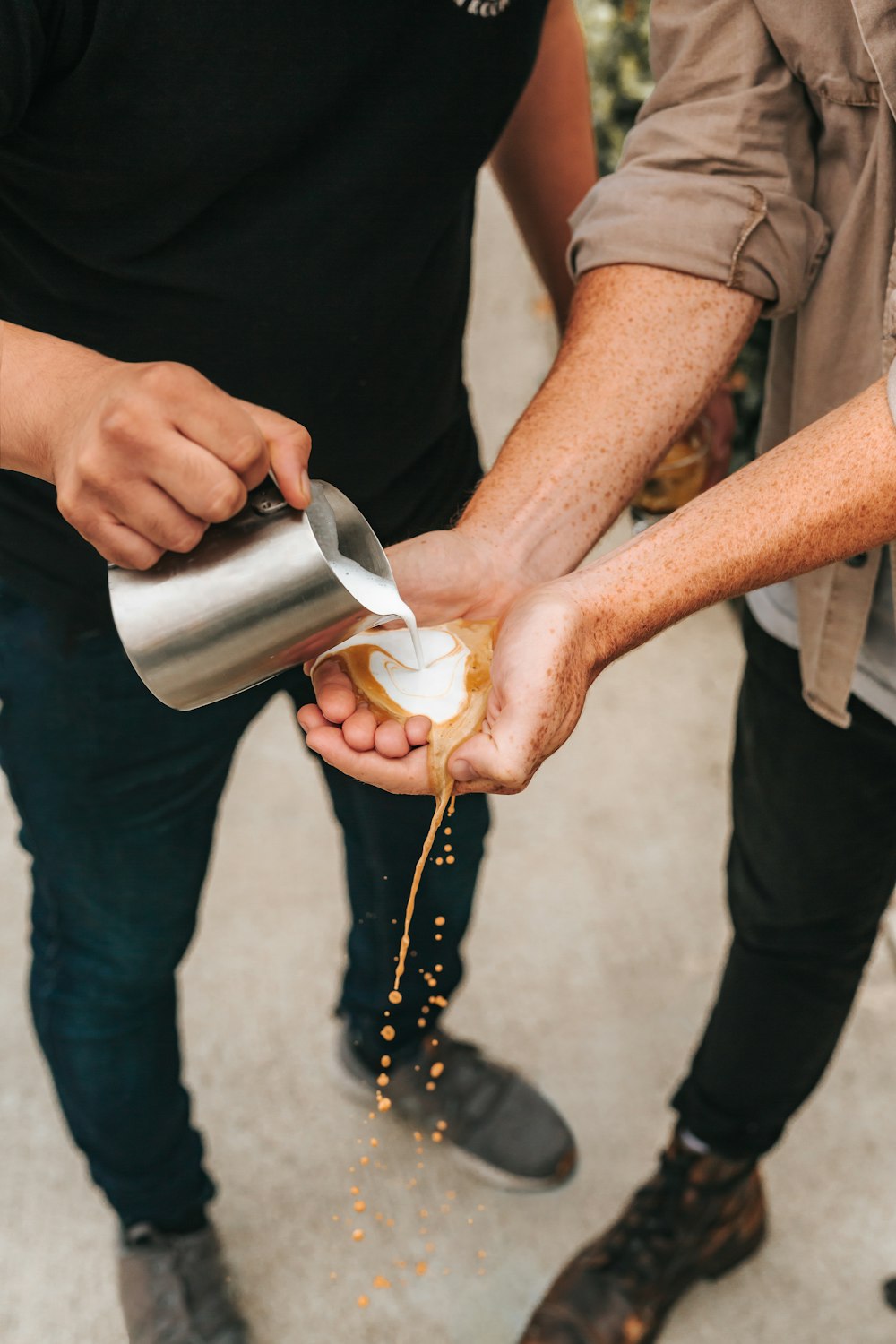 person pouring milk on silver cup