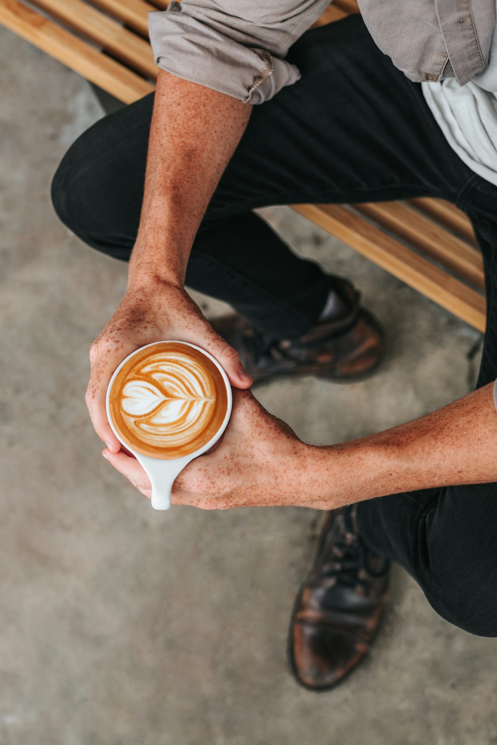 person holding brown and white ceramic mug