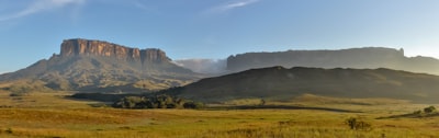 green grass field near brown mountain under white clouds during daytime venezuela teams background