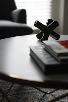 Elegant design objects arranged on a clean white table with open books nearby.